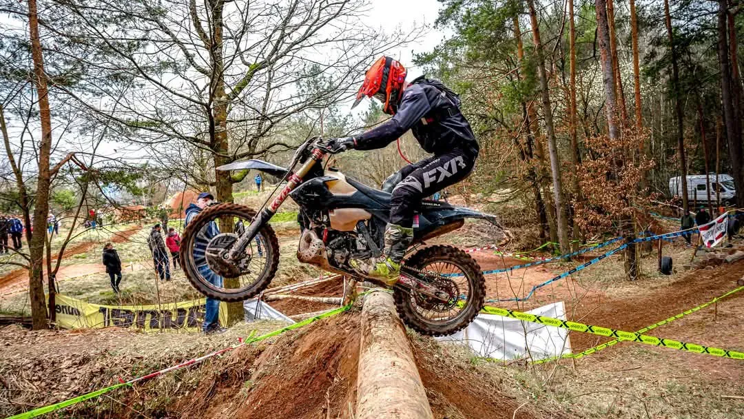 Leon Raimann springt mit dem Enduro-Motorrad über einen Baumstamm